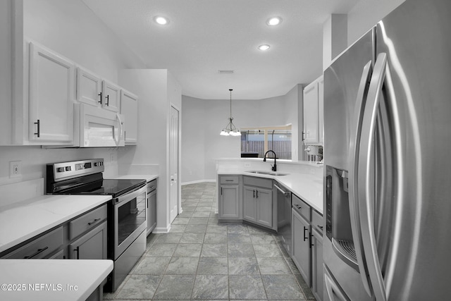 kitchen featuring hanging light fixtures, appliances with stainless steel finishes, sink, gray cabinetry, and a notable chandelier