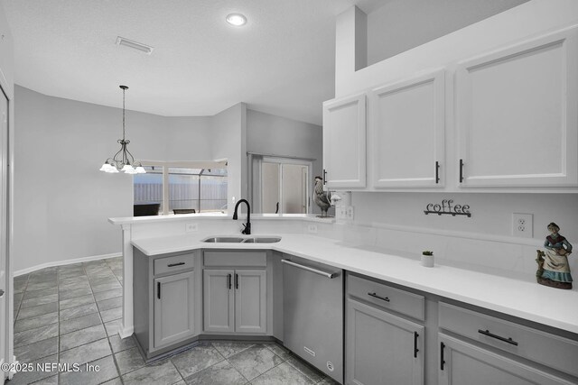 kitchen with stainless steel dishwasher, pendant lighting, sink, gray cabinets, and a textured ceiling