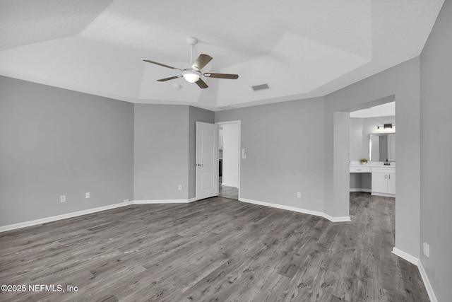 spare room featuring hardwood / wood-style floors, a textured ceiling, sink, a raised ceiling, and ceiling fan