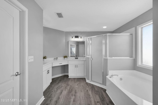 bathroom featuring hardwood / wood-style floors, a textured ceiling, shower with separate bathtub, and vanity