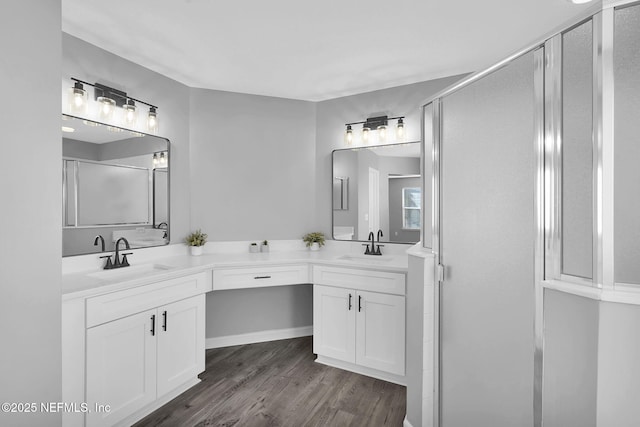 bathroom with hardwood / wood-style flooring, a shower with door, and vanity