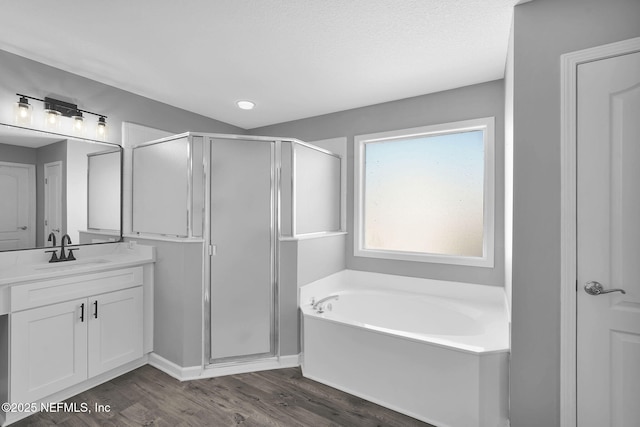 bathroom with hardwood / wood-style floors, vanity, a textured ceiling, and separate shower and tub