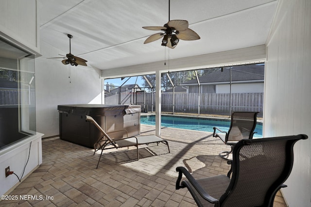 view of pool with a patio, ceiling fan, glass enclosure, and a hot tub