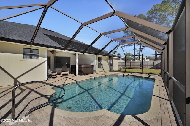 view of pool featuring glass enclosure, a patio, a hot tub, and ceiling fan