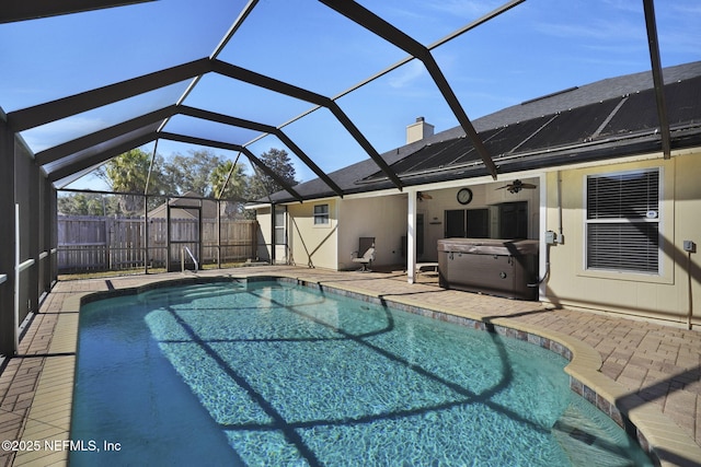 view of swimming pool featuring glass enclosure, a patio area, and a hot tub