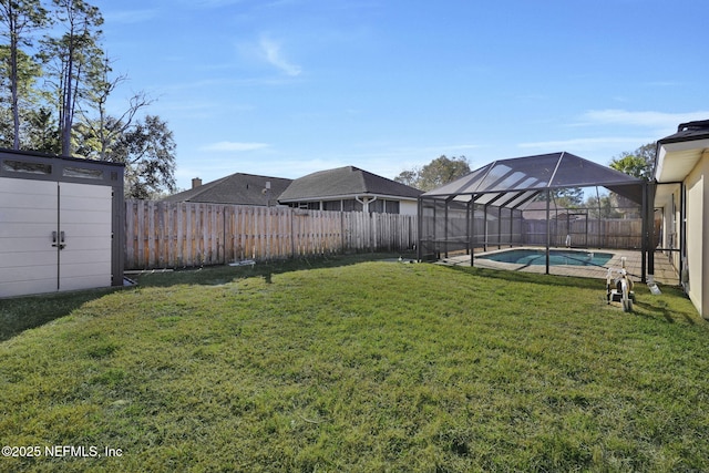 view of yard with a fenced in pool, glass enclosure, and a storage shed