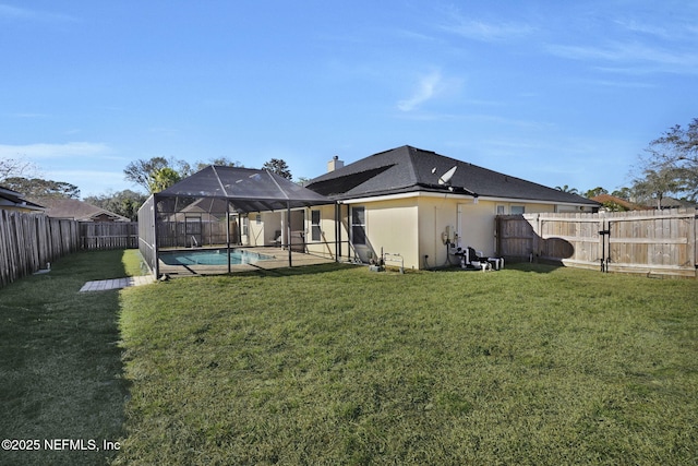 back of house featuring a lanai, a fenced in pool, and a yard