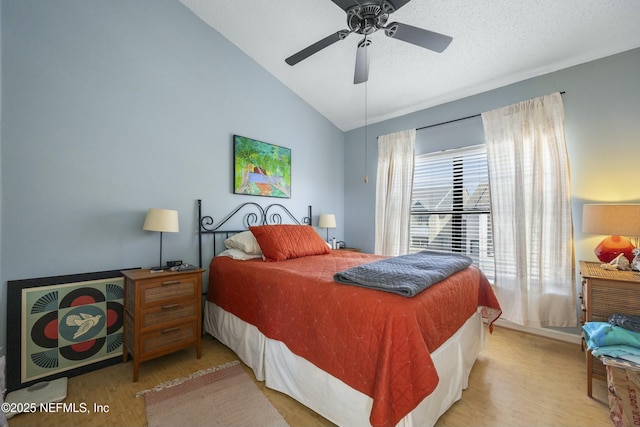 bedroom featuring light hardwood / wood-style flooring, ceiling fan, vaulted ceiling, and a textured ceiling