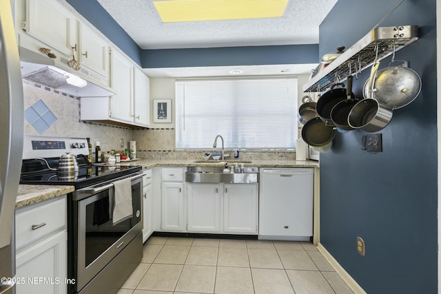 kitchen featuring light tile patterned flooring, white dishwasher, stainless steel range with electric cooktop, and white cabinets