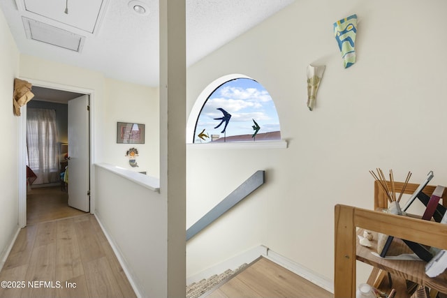 staircase featuring wood-type flooring and a textured ceiling