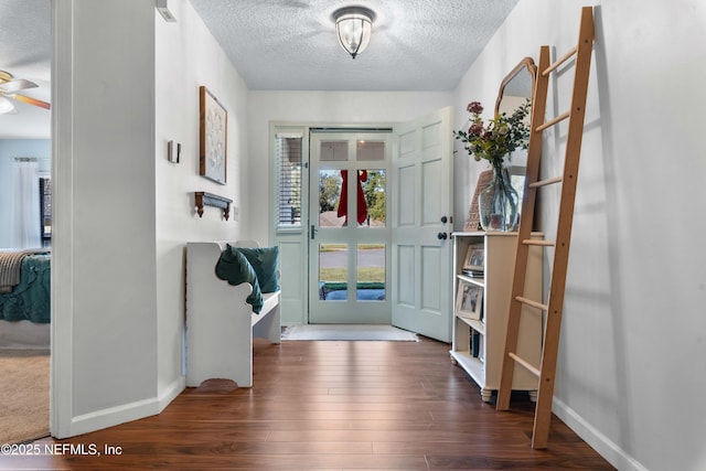 interior space featuring ceiling fan, dark wood-type flooring, and a textured ceiling