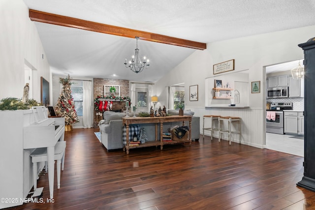 living room with a textured ceiling, dark hardwood / wood-style floors, a chandelier, and vaulted ceiling with beams