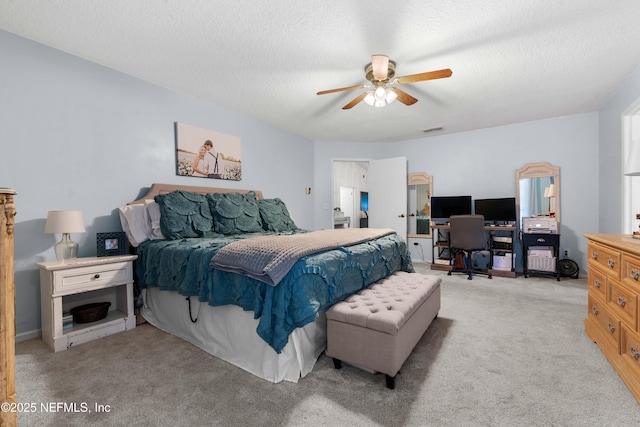 bedroom featuring ceiling fan, light colored carpet, and a textured ceiling