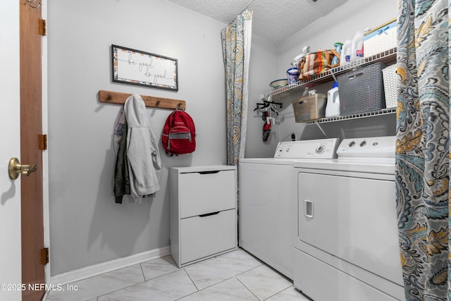 laundry room with a textured ceiling and washer and dryer