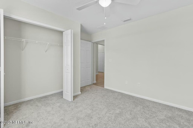 unfurnished bedroom with a closet, ceiling fan, and light colored carpet