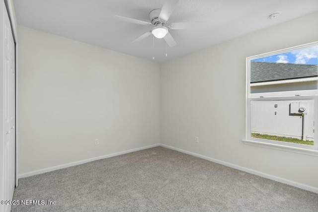 empty room with ceiling fan, plenty of natural light, and light colored carpet