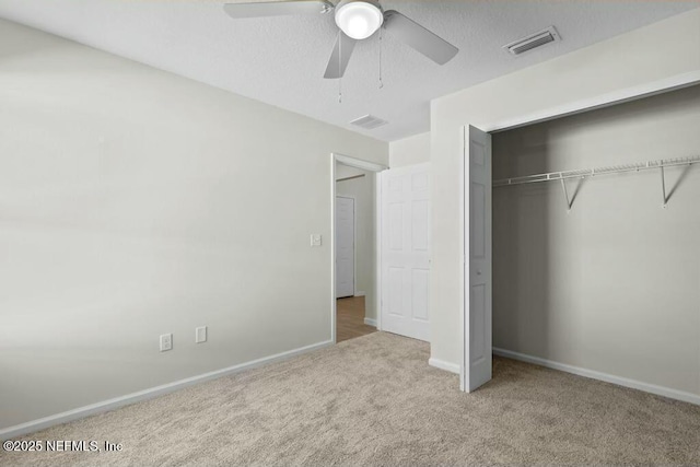 unfurnished bedroom with light carpet, a closet, and ceiling fan