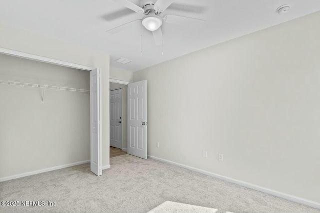 unfurnished bedroom with ceiling fan, light colored carpet, and a closet