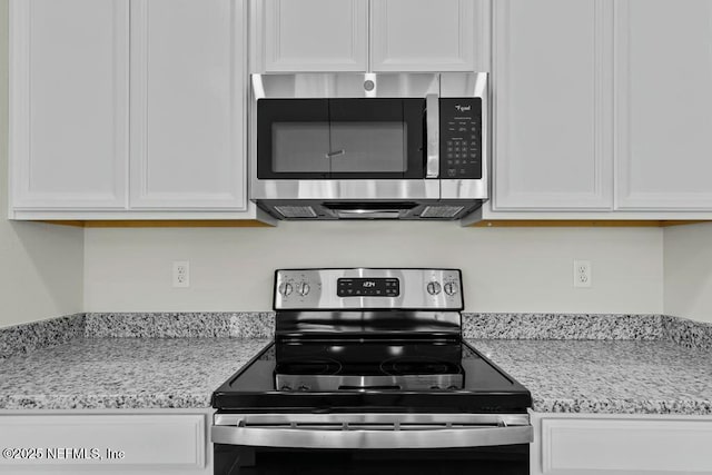 kitchen with white cabinetry, light stone countertops, and appliances with stainless steel finishes