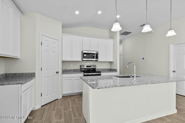 kitchen with sink, hanging light fixtures, white cabinets, and stainless steel appliances