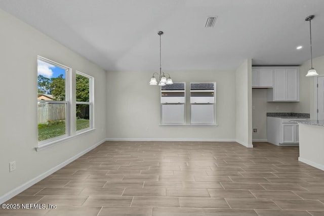 unfurnished dining area featuring a chandelier