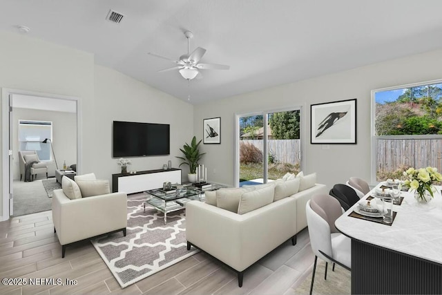 living room featuring vaulted ceiling and ceiling fan