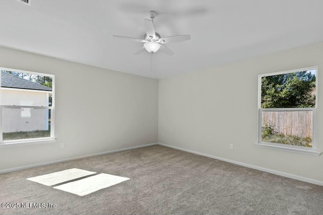 empty room featuring ceiling fan and light colored carpet