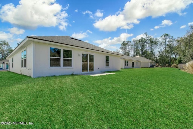 rear view of property featuring a lawn