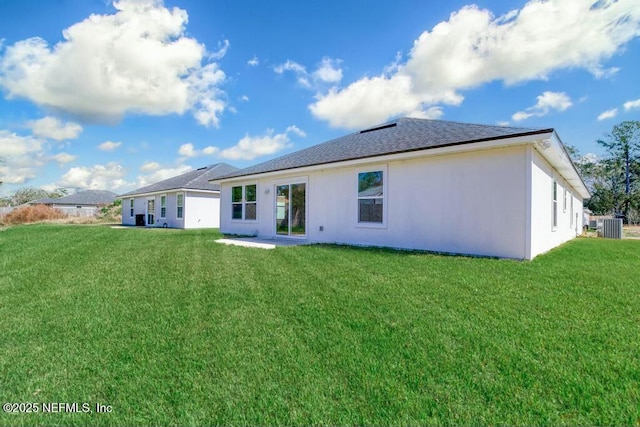 rear view of property featuring cooling unit and a yard