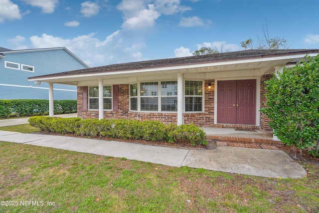 ranch-style home with a porch and a front yard