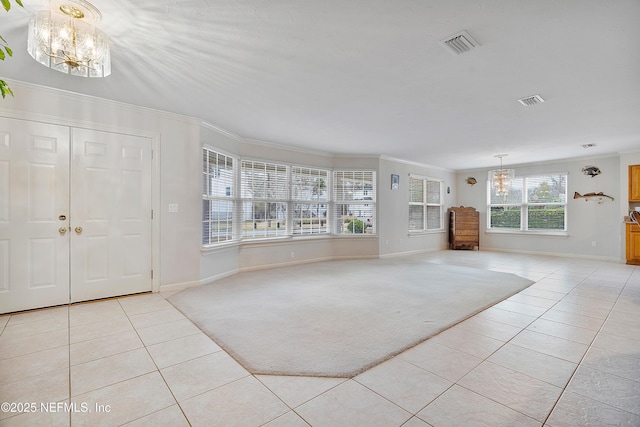 entrance foyer featuring ornamental molding, light colored carpet, and a notable chandelier