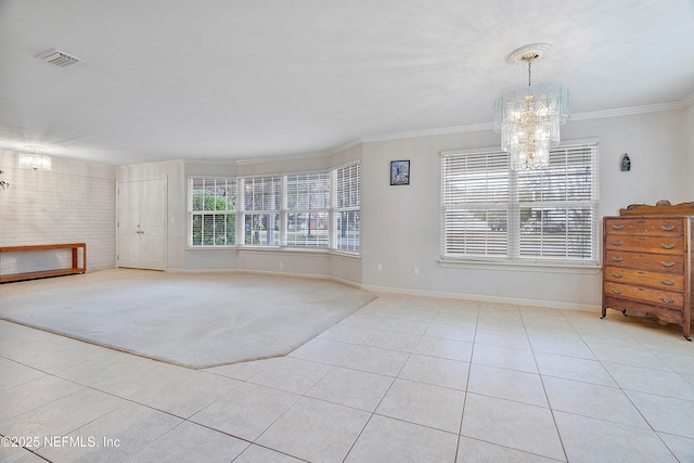 spare room with crown molding, light tile patterned floors, and a chandelier