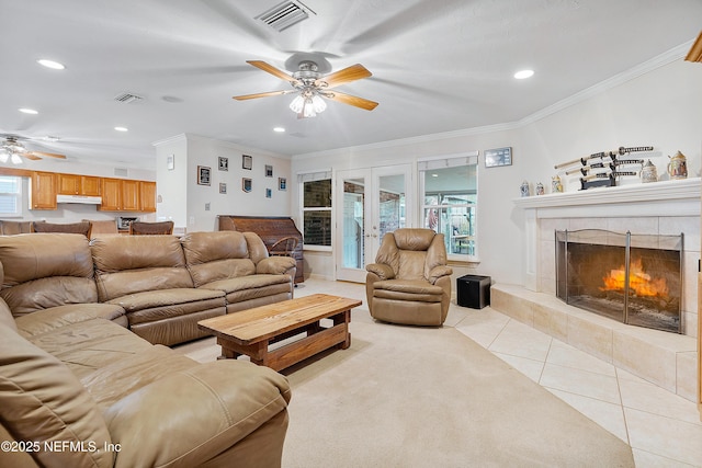 tiled living room with crown molding, a fireplace, french doors, and ceiling fan