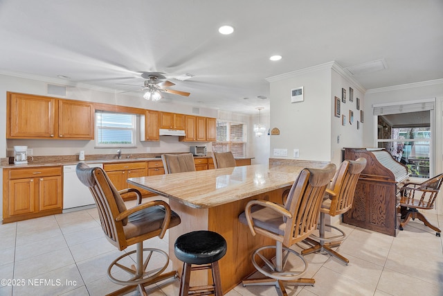 kitchen with sink, dishwasher, ornamental molding, a kitchen bar, and kitchen peninsula