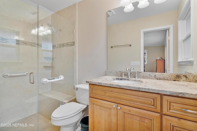 bathroom with vanity, a shower with shower door, and toilet