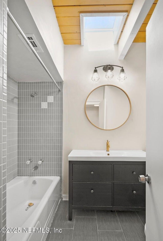 bathroom with tiled shower / bath, vanity, and tile patterned floors