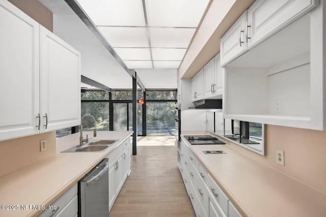 kitchen with stainless steel dishwasher, floor to ceiling windows, sink, and white cabinets