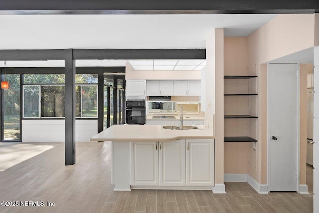 kitchen with sink, white cabinets, and black appliances