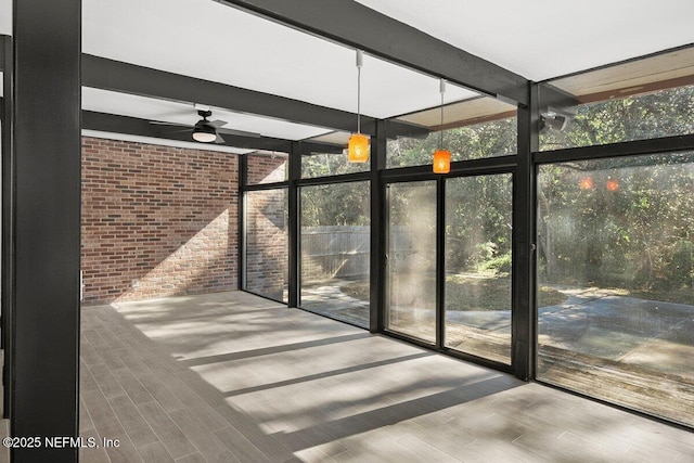 unfurnished sunroom with beamed ceiling and ceiling fan