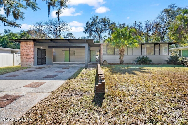 ranch-style home featuring a carport and a front lawn