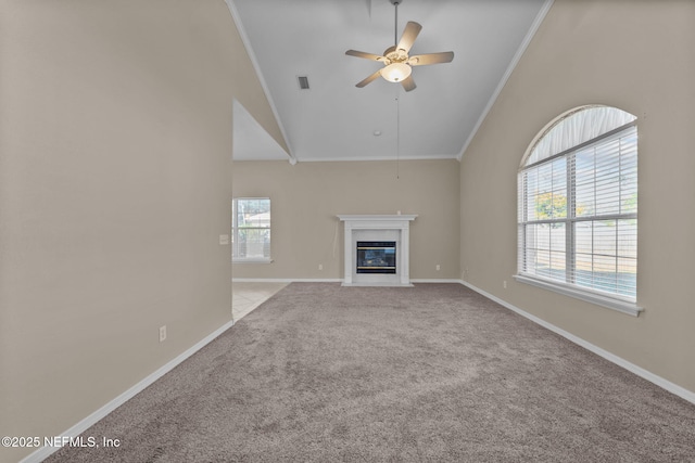 unfurnished living room featuring ceiling fan, ornamental molding, light carpet, and a wealth of natural light