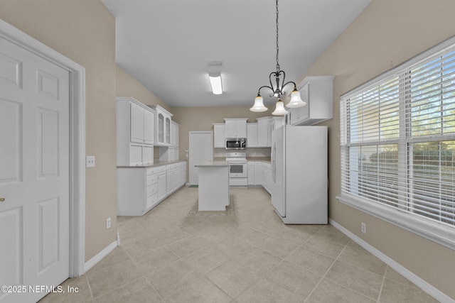 kitchen with white appliances, an inviting chandelier, a center island, white cabinets, and decorative light fixtures