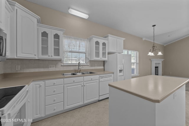 kitchen featuring sink, white appliances, a center island, white cabinets, and light tile patterned flooring