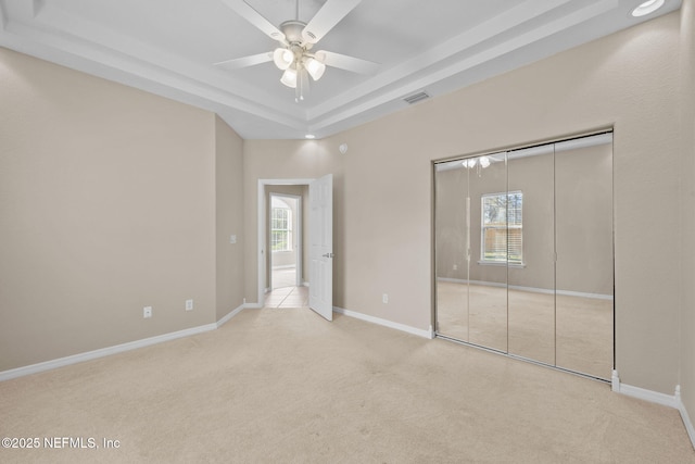 unfurnished bedroom featuring multiple windows, ceiling fan, and a closet