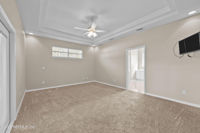 interior space with a tray ceiling, carpet floors, and ceiling fan