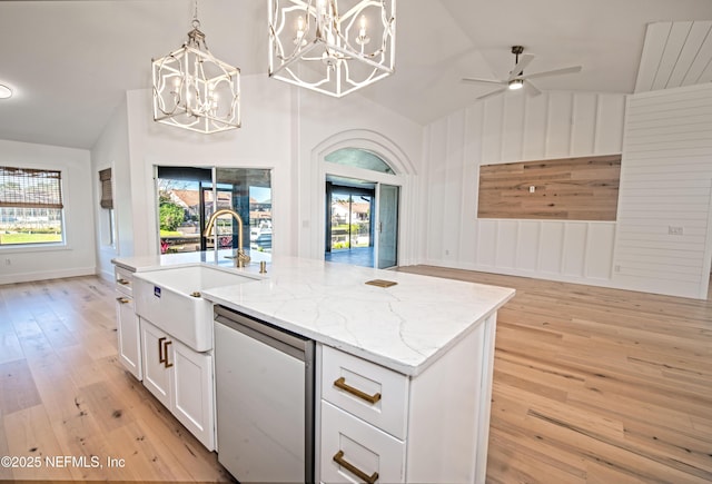 kitchen featuring lofted ceiling, an island with sink, light hardwood / wood-style floors, and sink