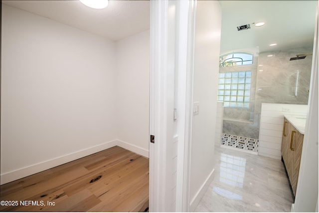 bathroom with vanity and a tile shower