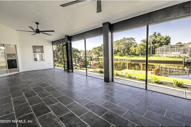 unfurnished sunroom featuring lofted ceiling, ceiling fan, and a water view