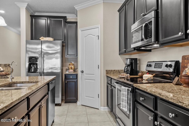 kitchen with light stone countertops, light tile patterned floors, sink, ornamental molding, and stainless steel appliances