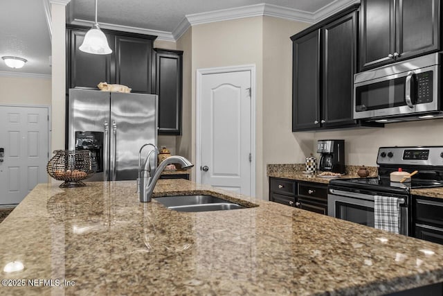 kitchen featuring hanging light fixtures, appliances with stainless steel finishes, sink, light stone counters, and ornamental molding